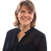 smiling woman with short blonde hair in a black collared blouse