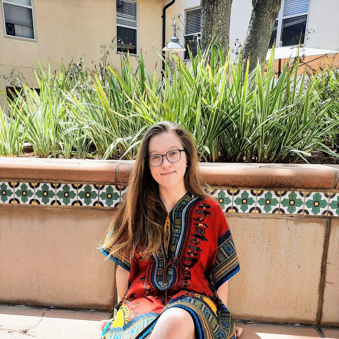 PhD candidate Simone Kurial sits on a sunny day outside with plants